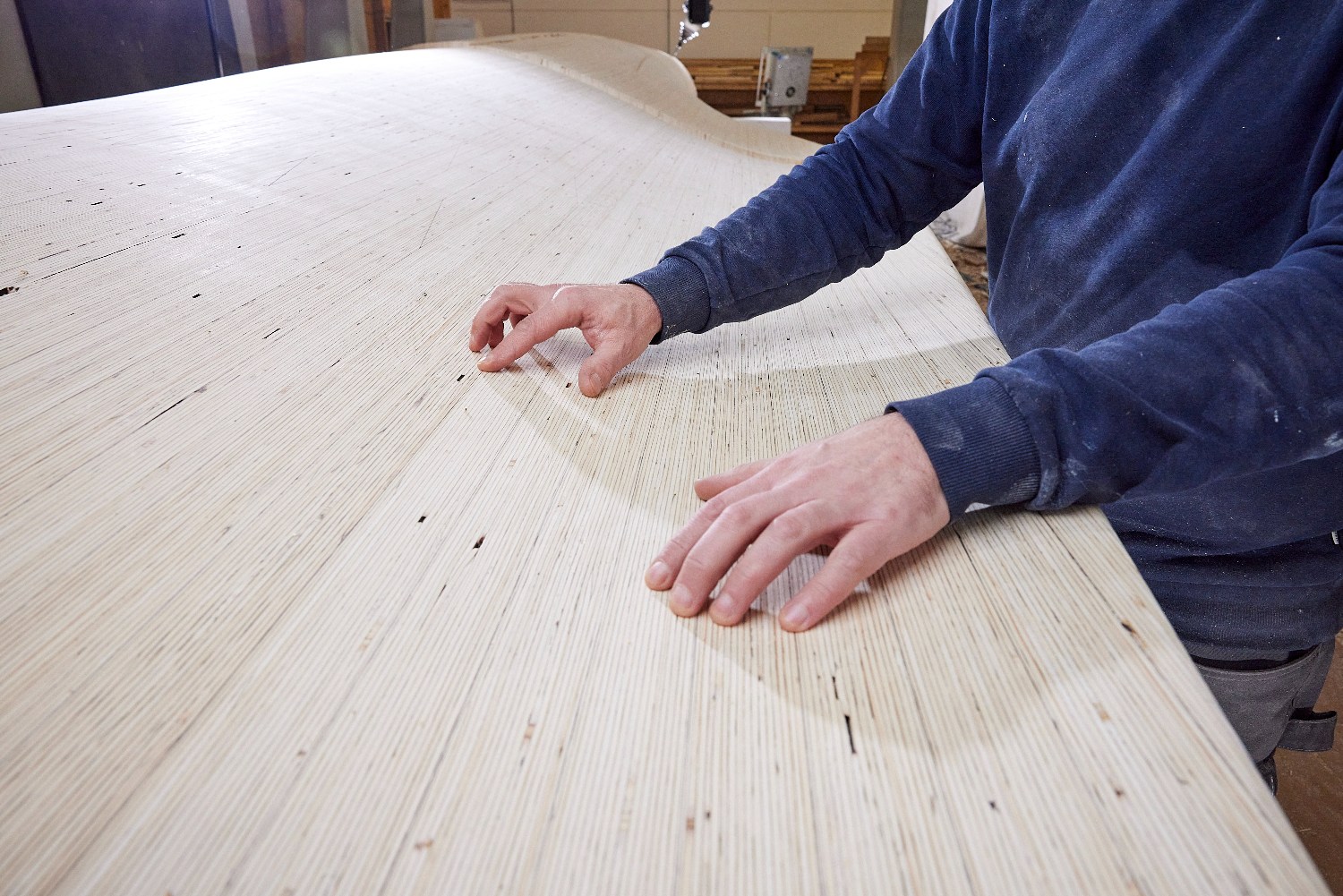 Hands on a laminated veneer lumber blade surface