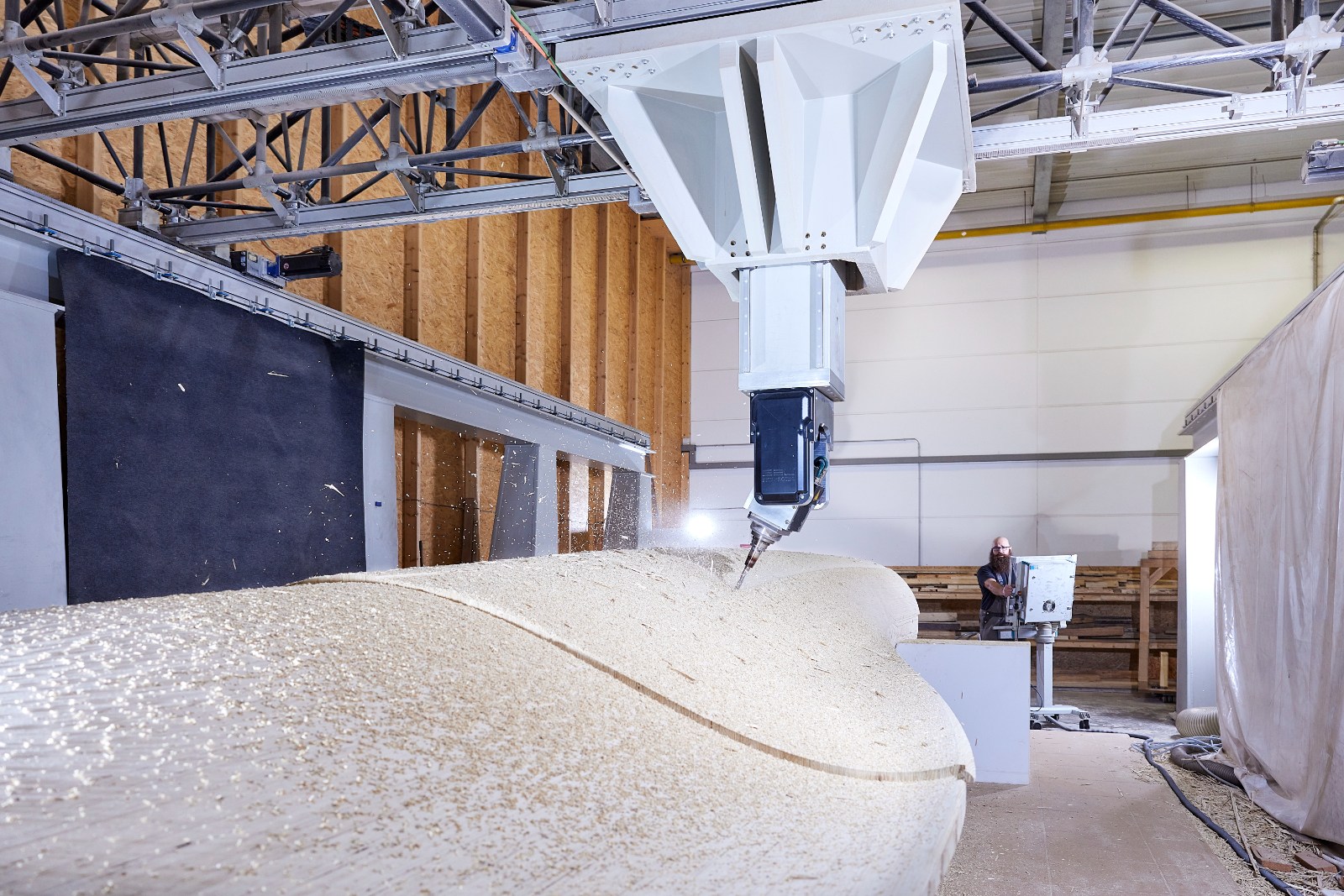 Five-axis CNC machine milling a wood-based wind turbine blade in the VB1F production hall